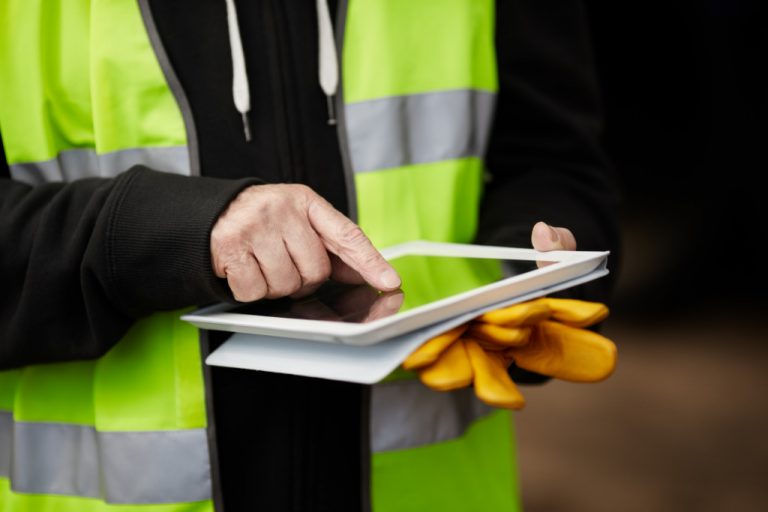 contractor touching his tablet while wearing ppeb