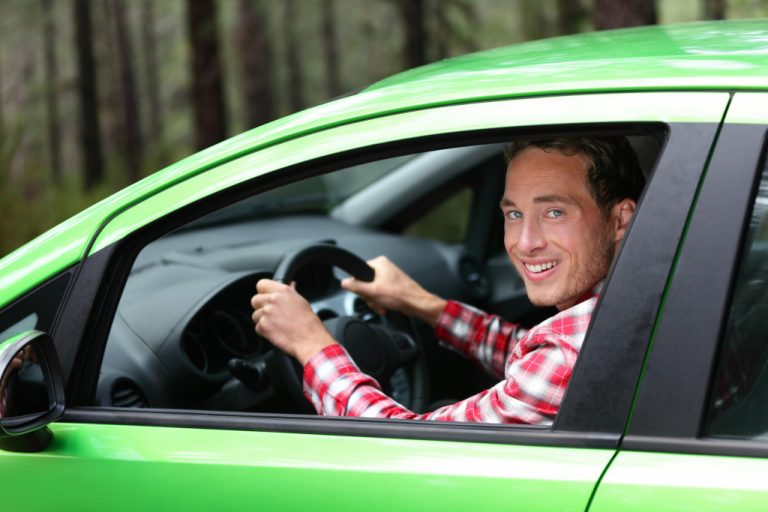 man driving a green car
