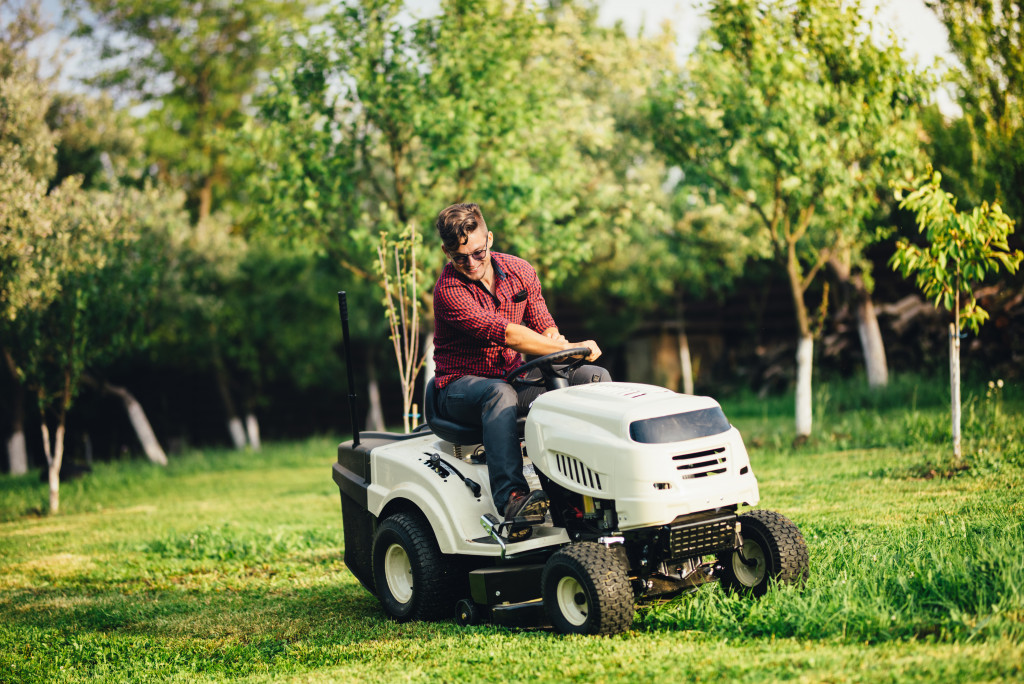 a man in a mower cutting grass