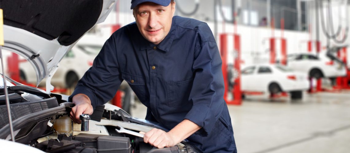 A car mechanic is repairing a car